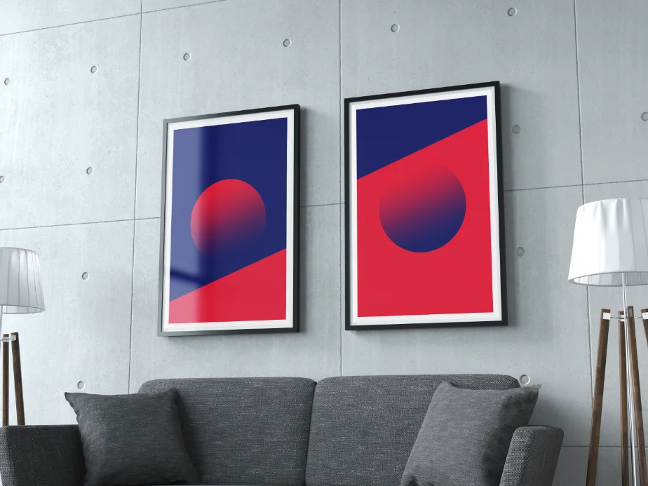 Two framed abstract art prints, deep blue and red with a gradient sphere, hung above a sofa